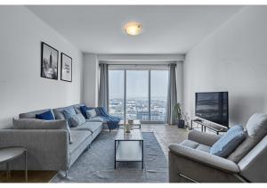 迪拜Amazing 3BR Apartment next to Emirates Towers Metro in DIFC的带沙发和大窗户的客厅