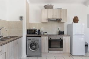 布鲁堡史特兰Azure 11的厨房配有冰箱和洗衣机。