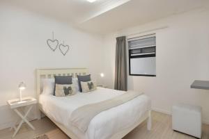布鲁堡史特兰Azure 11的白色的卧室设有一张大床和一个窗户