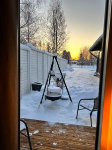 罗瓦涅米Guest house - Northern tealight的雪地覆盖的院子中的秋千