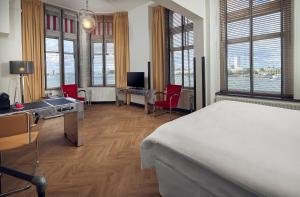 鹿特丹韦斯特考得酒店的卧室配有一张床、一张桌子和椅子