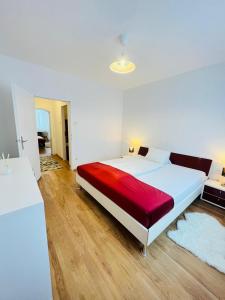 林茨Magnifique Appartment的卧室配有一张大白色床和红色毯子