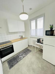 林茨Magnifique Appartment的厨房配有白色橱柜和炉灶烤箱。