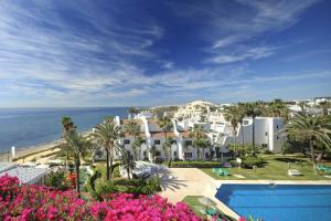 马贝拉珊瑚海滩公寓式酒店的享有带游泳池和大海的度假胜地的景致