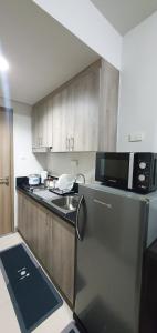 马尼拉C Place - Capsule A的厨房配有不锈钢冰箱和微波炉。