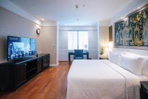 曼谷曼谷拉查丹利中心酒店的酒店客房设有一张大床和一台电视。