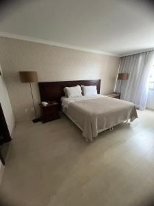 巴西利亚Brasil 21 suite flat的一间卧室配有一张大床和两盏灯。
