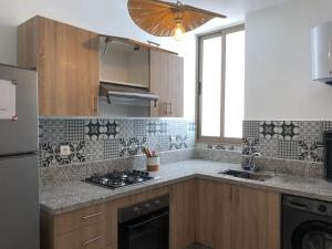 索维拉élégant appartement Essaouira的厨房配有水槽和炉灶 顶部烤箱