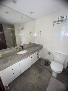 巴西利亚Brasil 21 suite flat的一间带卫生间、水槽和镜子的浴室