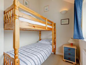 布德4 Bed in Bude 50591的一间卧室配有双层床和蓝色窗帘