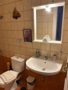 伊利达Kea Amazing View Maisonette的一间带水槽和卫生间的浴室以及窗户。