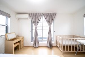 东京Shinokubo guest house的一间卧室设有一张婴儿床和大窗户
