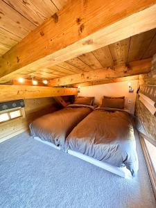 阿沃里亚兹Chalet Flocon - luxury ski chalet by Avoriaz Chale的一间带两张木天花板床的卧室