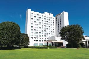 成田International Resort Hotel Yurakujo的前面有草坪的白色大建筑