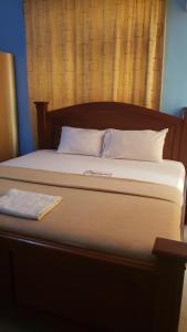 PrampramDreamers Lodge的一张带木制床头板和白色枕头的床