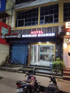 布巴内什瓦尔Hotel Bishram Bhawan,Bhubaneswar的两辆摩托车停在酒店前面,上面有标志