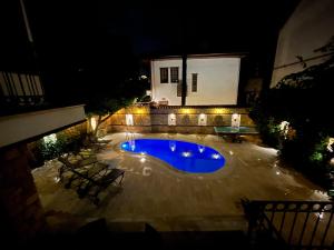 安塔利亚Attalos Villa的夜间在院子里的游泳池