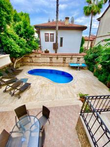 安塔利亚Attalos Villa的后院设有游泳池、桌子和椅子