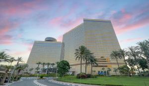 迪拜迪拜海滨大道凯悦酒店的两座高大的建筑,在马路前有棕榈树