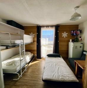 萨莫安斯Samoens 1600, ski au pied的客房设有两张双层床和一扇窗户。
