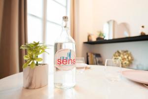 桑斯Le Laurencin Sens - Le Zen的桌子上放着一瓶水,放着植物