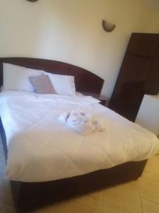 赫尔格达艾菲尔赫尔格达酒店的一张铺有白色床单的床和木制床头板