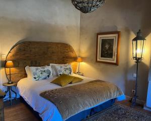 IssusLe Clos de Mara的一间卧室配有一张大床和木制床头板