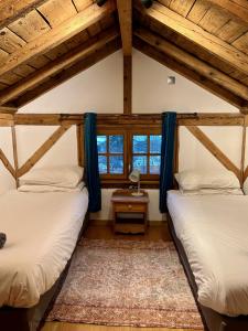 夏蒙尼-勃朗峰Gorgeous Mini-Chalet Chamonix的带2扇窗户的客房内的2张床