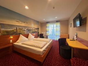 阿勒斯贝格罗斯湖酒店的配有一张床和一张书桌的酒店客房