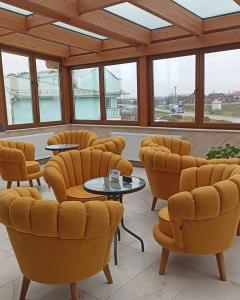 沙巴茨Smestaj & Spa Protić的一间设有黄色椅子和桌子的等候室