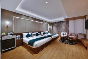 阿姆利则Quality Inn Elite, Amritsar的酒店客房带一张大床和一把椅子