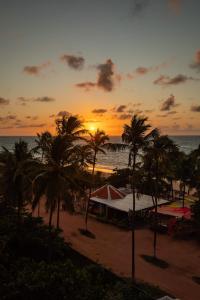 马塞约Moriah Maceió Beach Hotel的棕榈树海滩上的日落和海洋