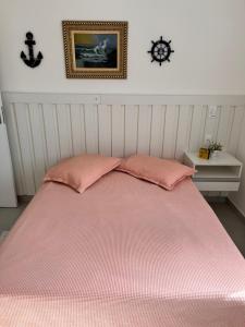 乌巴图巴Apt Familiar-Condomínio fechado UBATUBA的床上有两张粉红色枕头