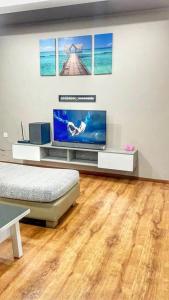 古晋Cozy Homestay Vivacity Megamall的客厅设有平面电视和木地板。