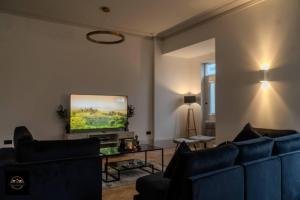 艾纯查姆Lovely 3-Bed Apartment in Altrincham的客厅配有蓝色的沙发和平面电视。