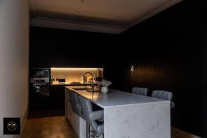 艾纯查姆Lovely 3-Bed Apartment in Altrincham的厨房设有黑色墙壁和桌椅