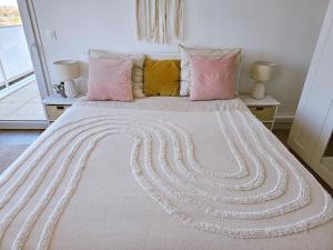 蒙特Lakeside Provence - Appartement 4 étoiles face au lac de Monteux的卧室配有一张带粉红色枕头的大床