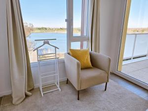 蒙特Lakeside Provence - Appartement 4 étoiles face au lac de Monteux的窗户间里带枕头的椅子