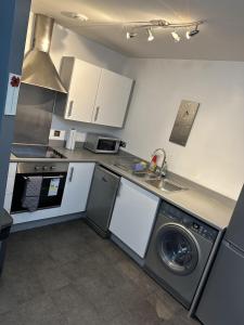 伍尔弗汉普顿Remarkable 2-Bed Apartment in Wolverhampton的厨房配有洗衣机和水槽
