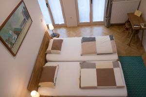 PetrovčeBed & Breakfast Dvorec的客房配有两张带枕头和桌子的床。