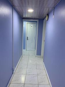 迪拜Bright Rooms的一条带蓝色墙壁和白色门的走廊
