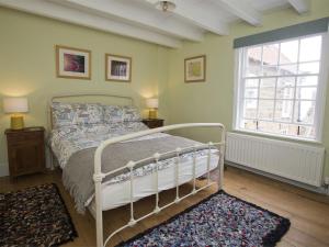 罗宾胡兹贝2 Bed in Robin Hoods Bay G0085的卧室配有白色的床和窗户。