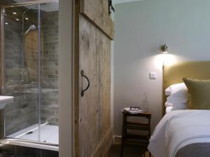 戈斯兰1 Bed in Goathland G0140的一间带淋浴的浴室和一张带玻璃门的床