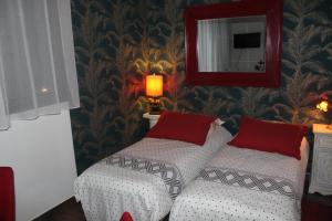 马拉科夫PARIS de FLORE Stane的一间卧室配有两张带红色枕头和镜子的床