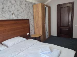 切尔诺夫策City Club European的一间卧室配有一张带木制床头板和门的床。