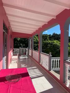 黑角Terrasse des Manguiers : logement indépendant的红色地毯上的粉红色门廊