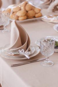 阿斯塔纳托米里斯精品酒店的白桌,带盘子和玻璃杯及餐巾纸
