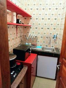 杜阿拉Residence Sighaka - Studio Meublé VIP avec WiFi, Gardien, Parking的一间带水槽和炉灶的小厨房