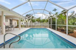 萨尼贝尔Villa Island Pearl - Roelens Vacations的一座玻璃屋顶房子中的游泳池