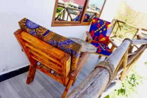 吉汶瓦Asili Nyumbani Residence的一间设有两把椅子和镜子的房间